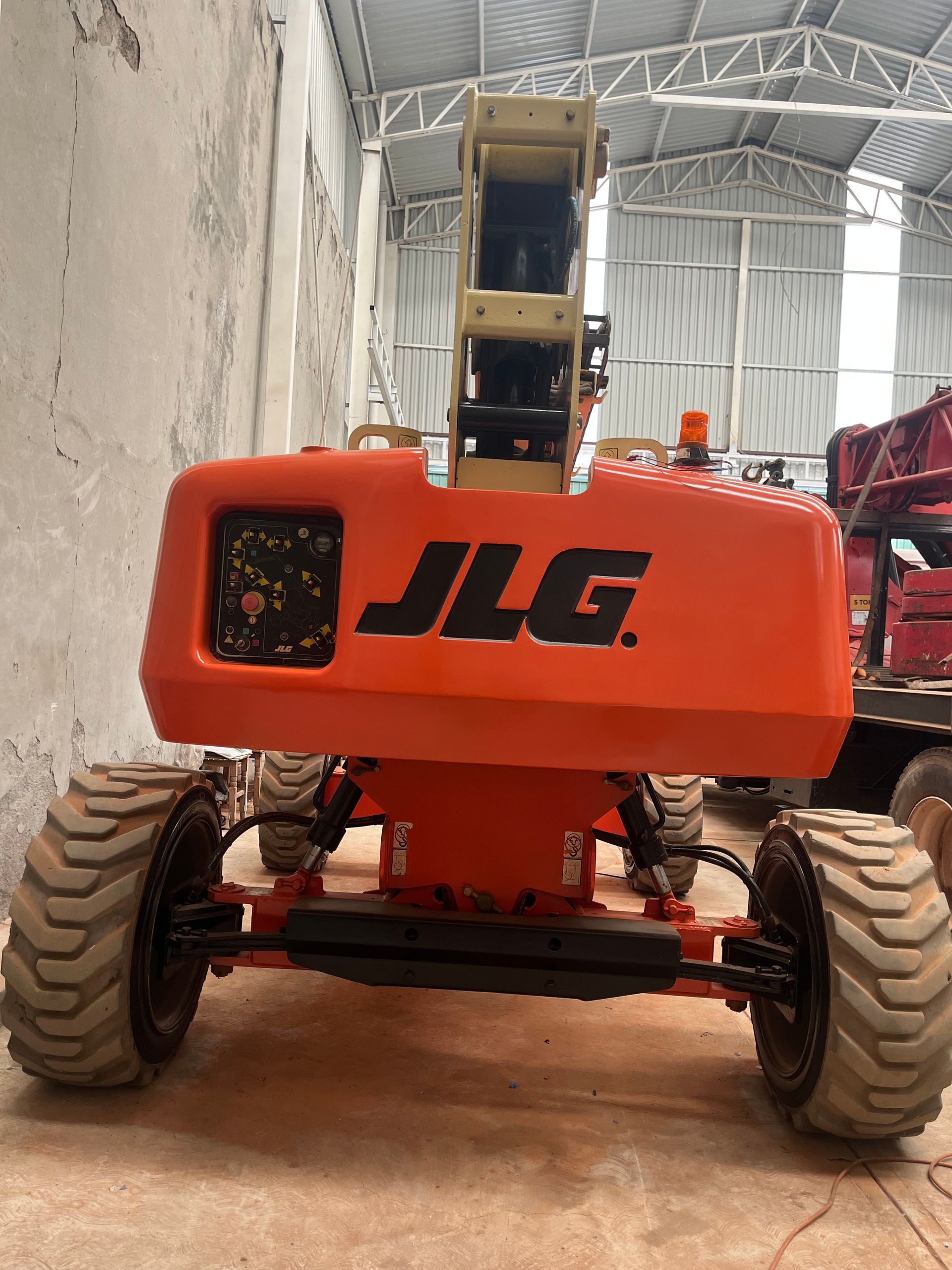 Plataforma elevadora naranja con brazo levantado sobre fondo azul y blanco.