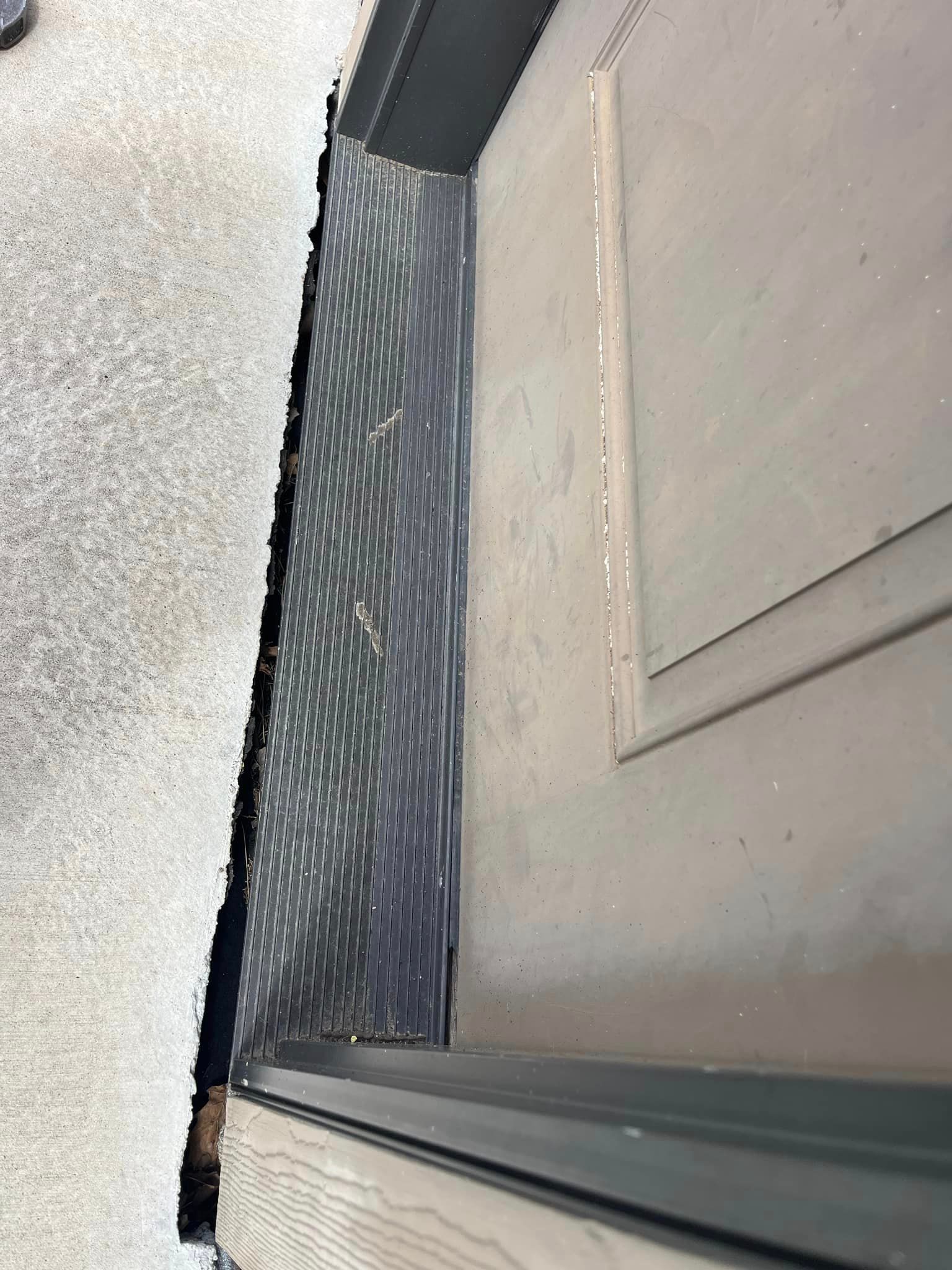 A close up of a door with a black mat on it.