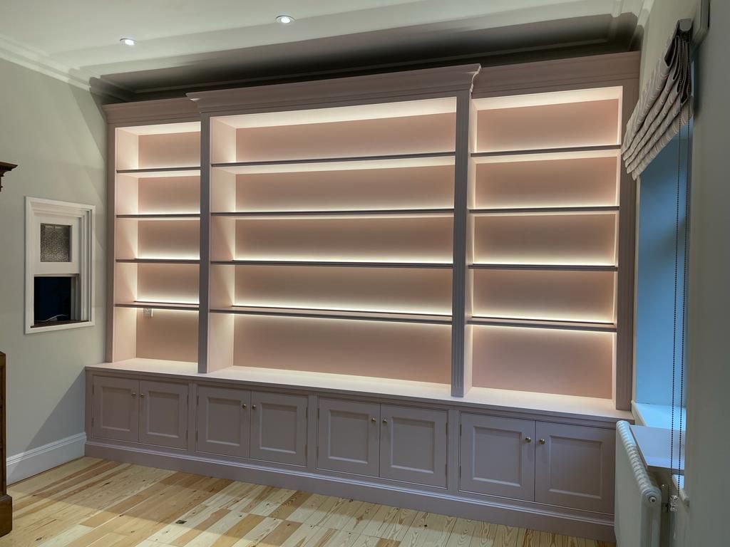 a large fitted home library with lights