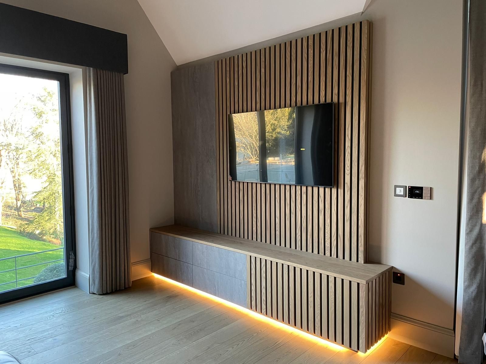 a living room with a flat screen tv mounted on the wall .