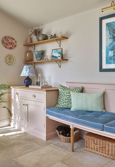 a corner of a room with a bench and shelves