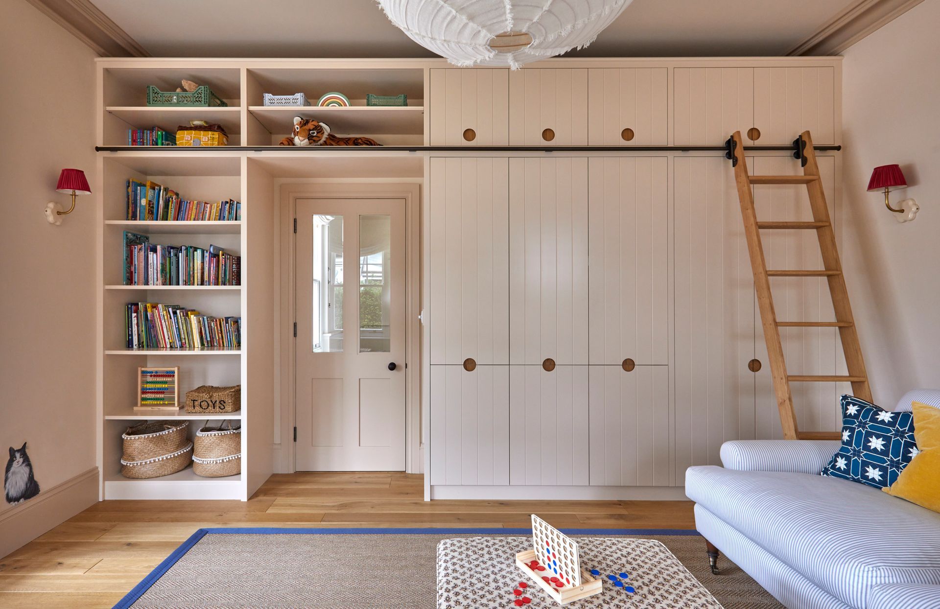 a living room with green shelves filled with books and a flat screen tv .