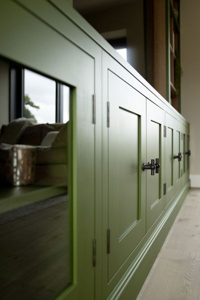 a green cabinet with a couch in the background