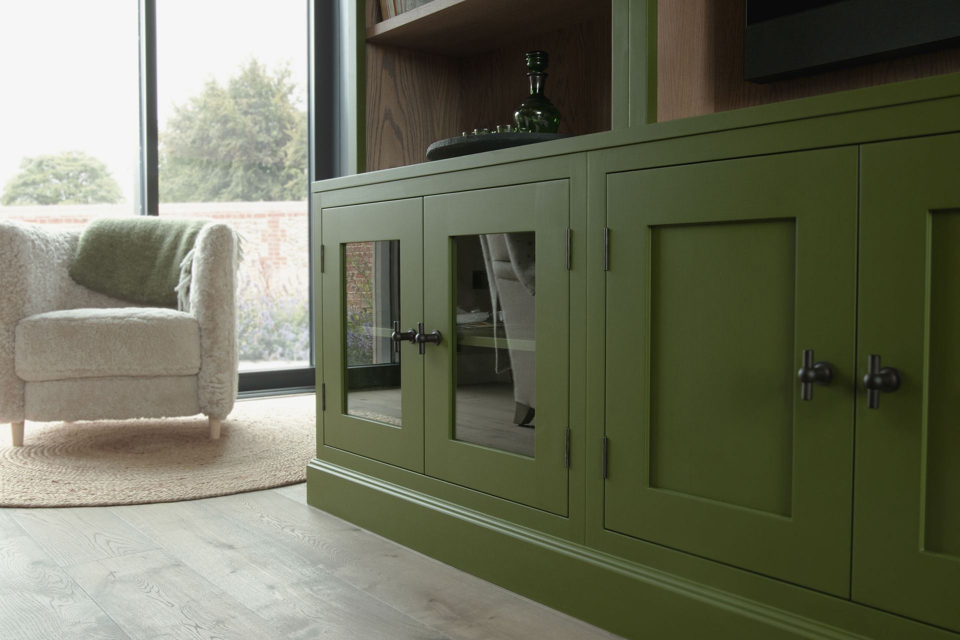 a living room with green fitted media units