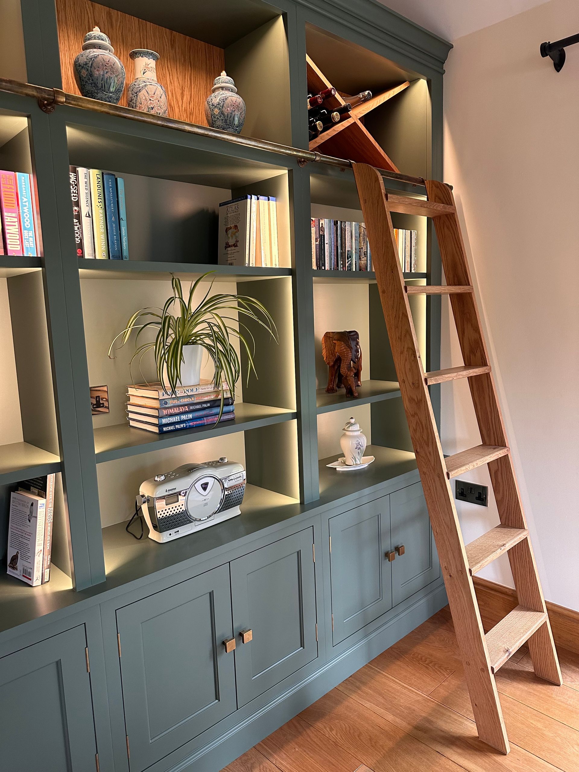 a custom library with a wooden ladder leading up to it .