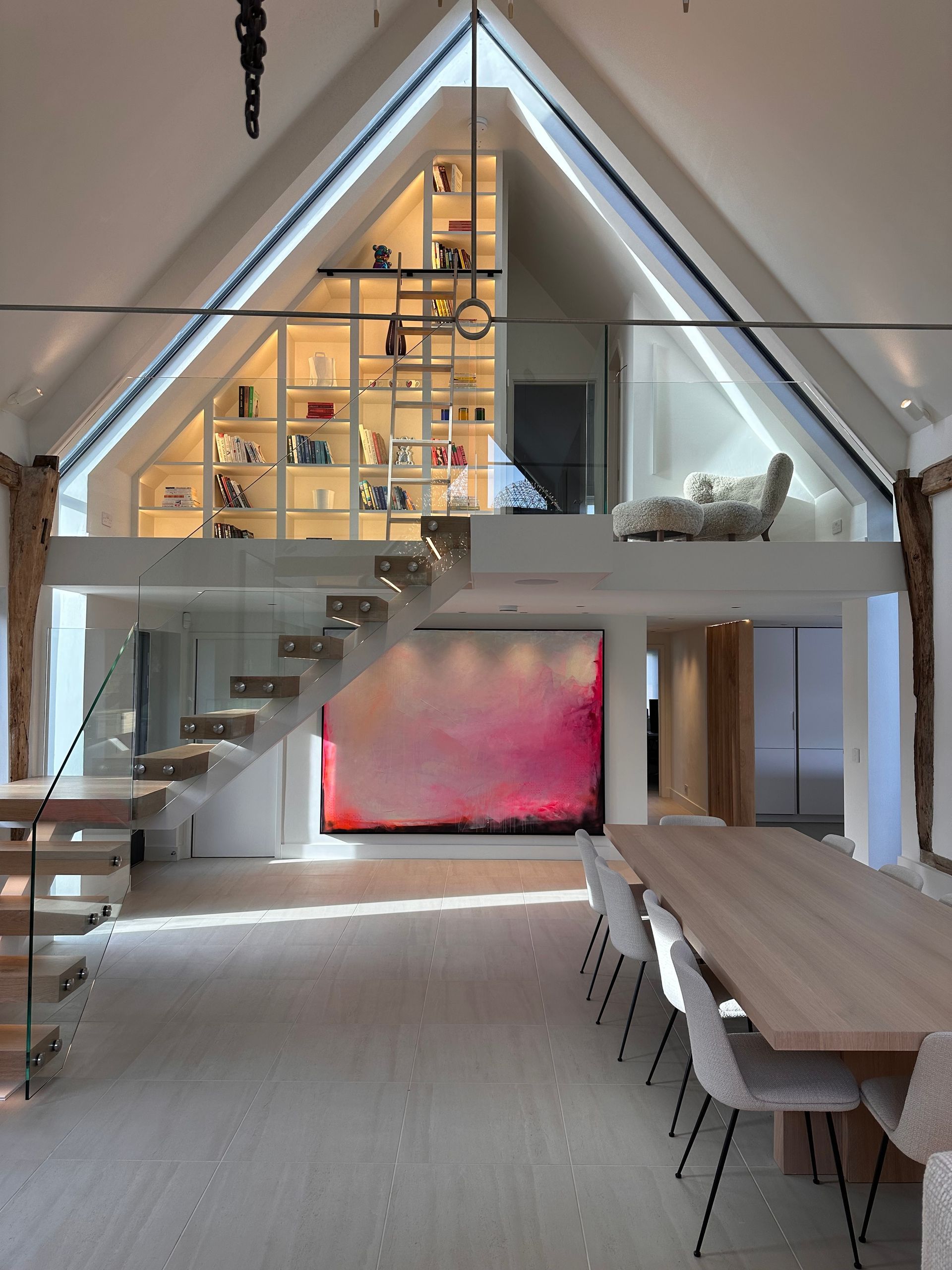 a large room with a table and chairs and stairs