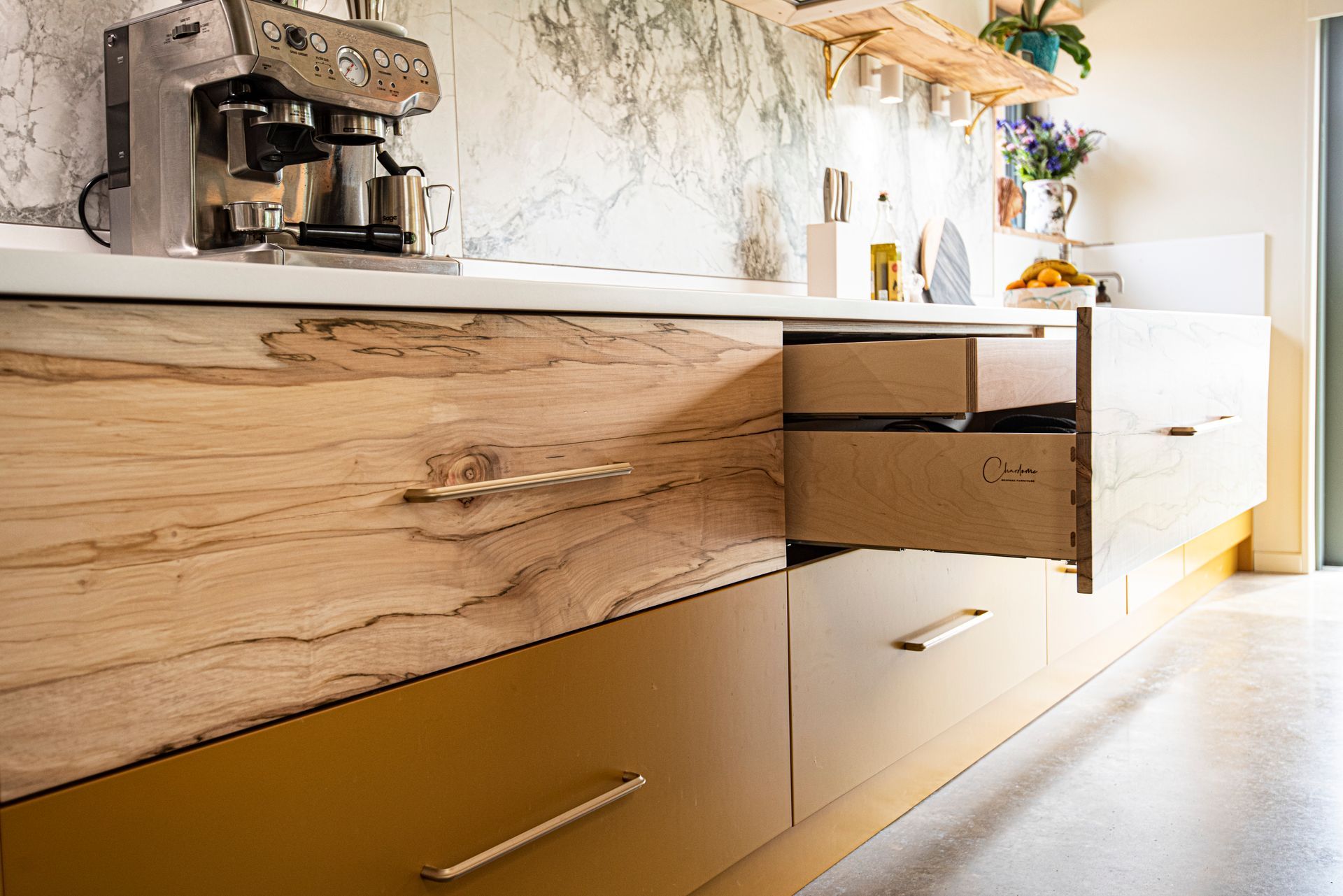 a high end kitchen with wooden drawers and a coffee maker