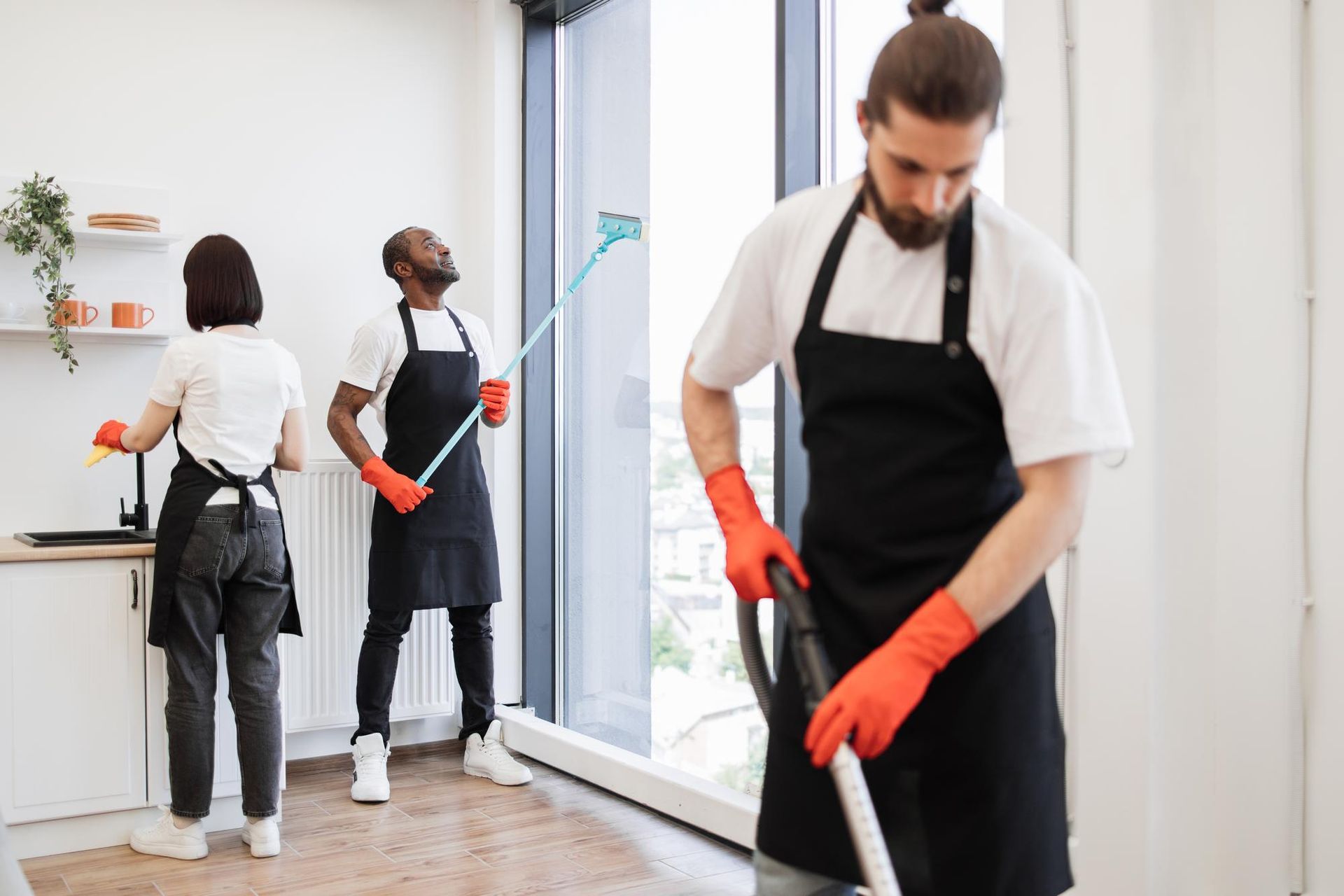 A group of people are cleaning a kitchen together.