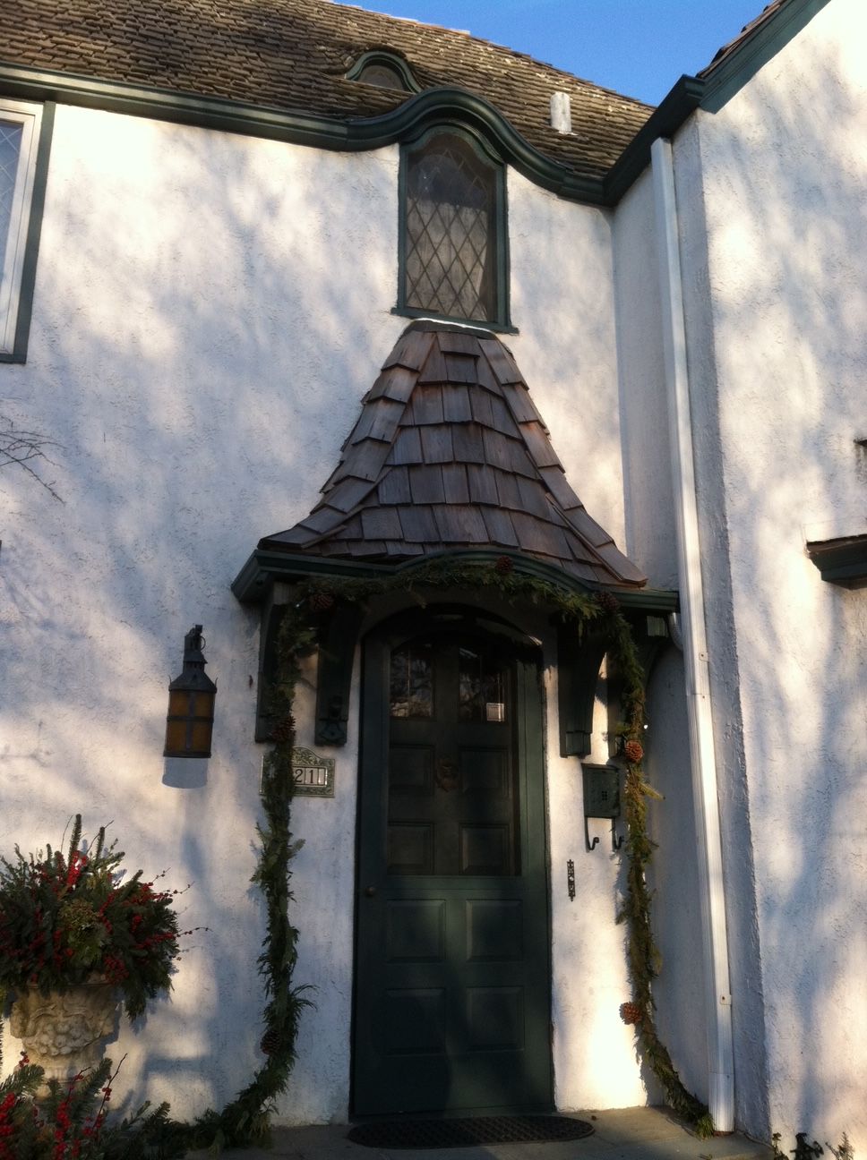 A white house with a green door and a roof