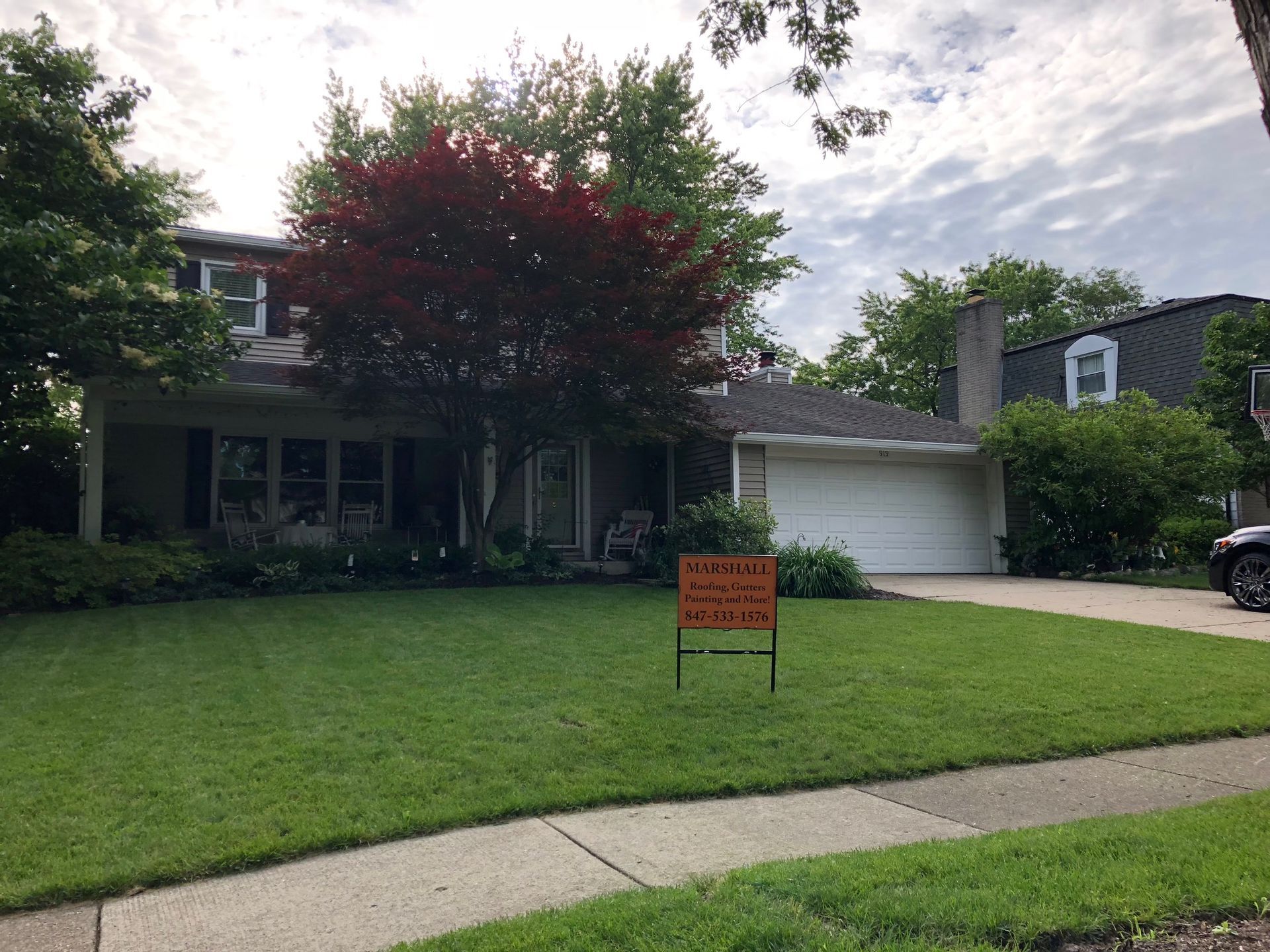A house with a for sale sign in front of it
