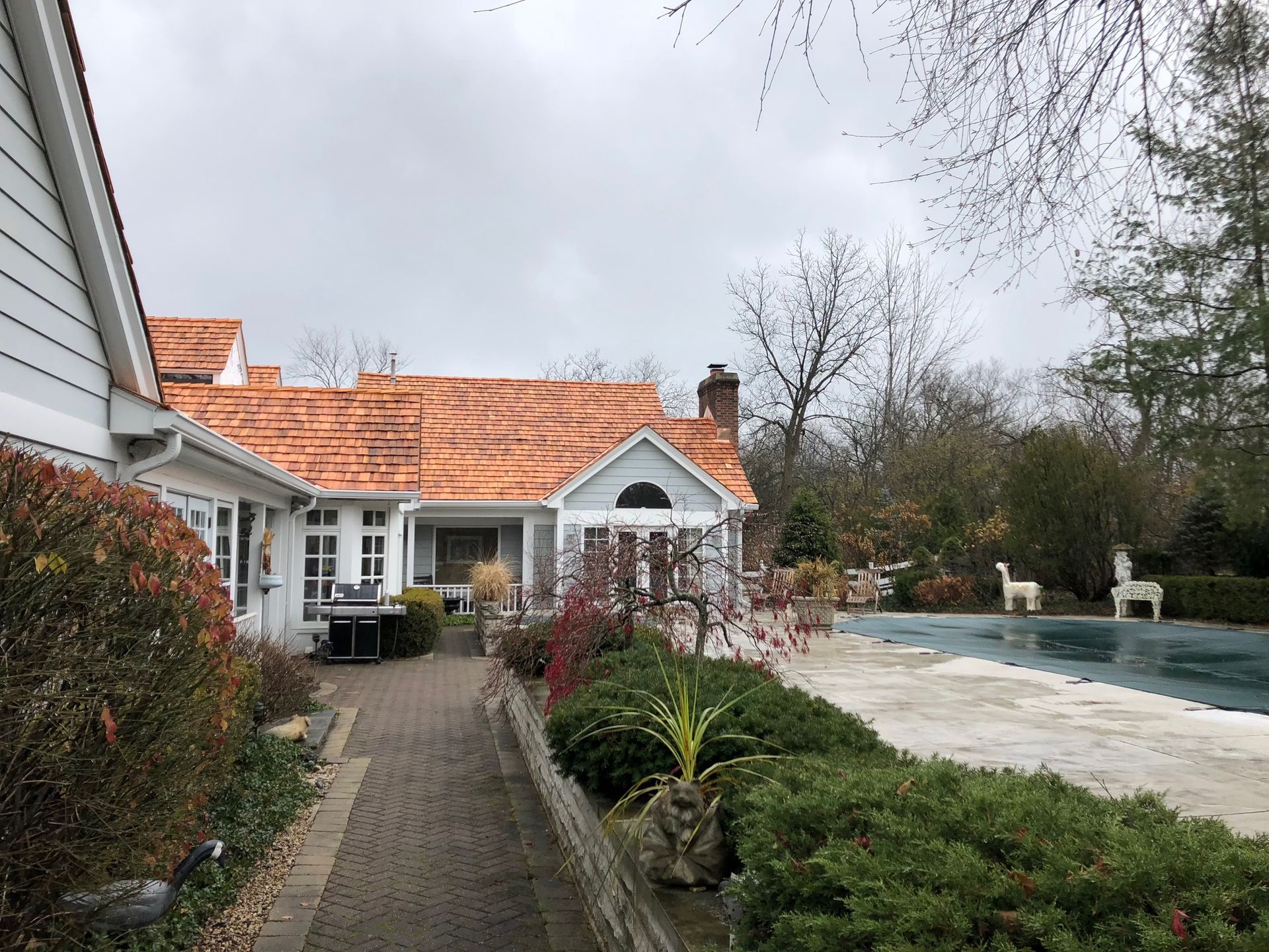 A house with a copper roof and a swimming pool in the backyard.