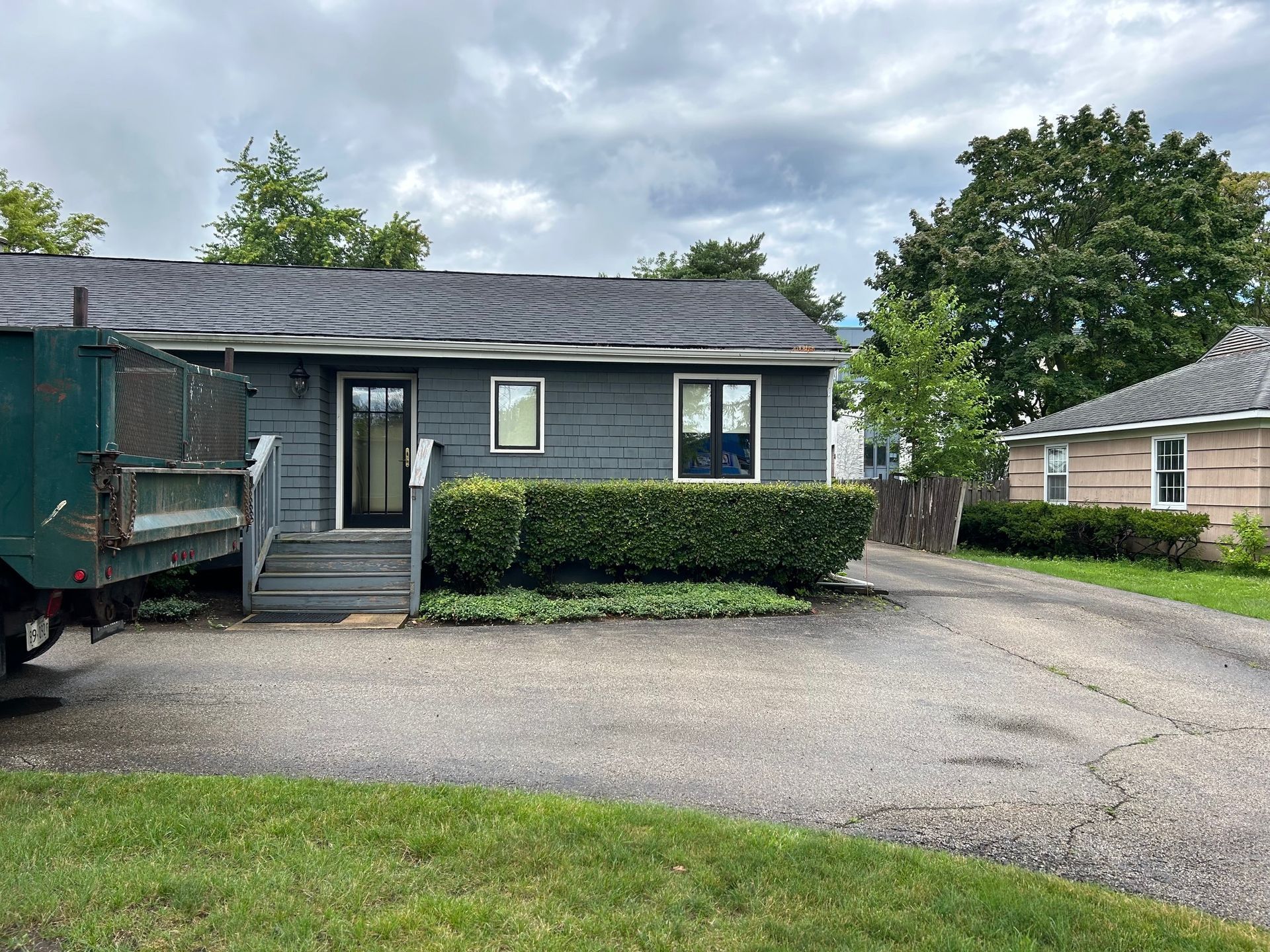 A dumpster is parked in front of a house.