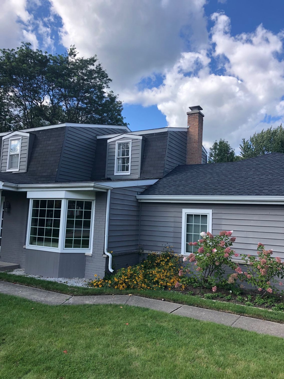 A house with a roof that has a chimney on it.