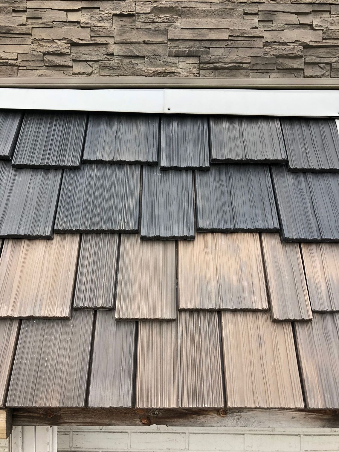 A close up of a wooden shingle roof on a house.