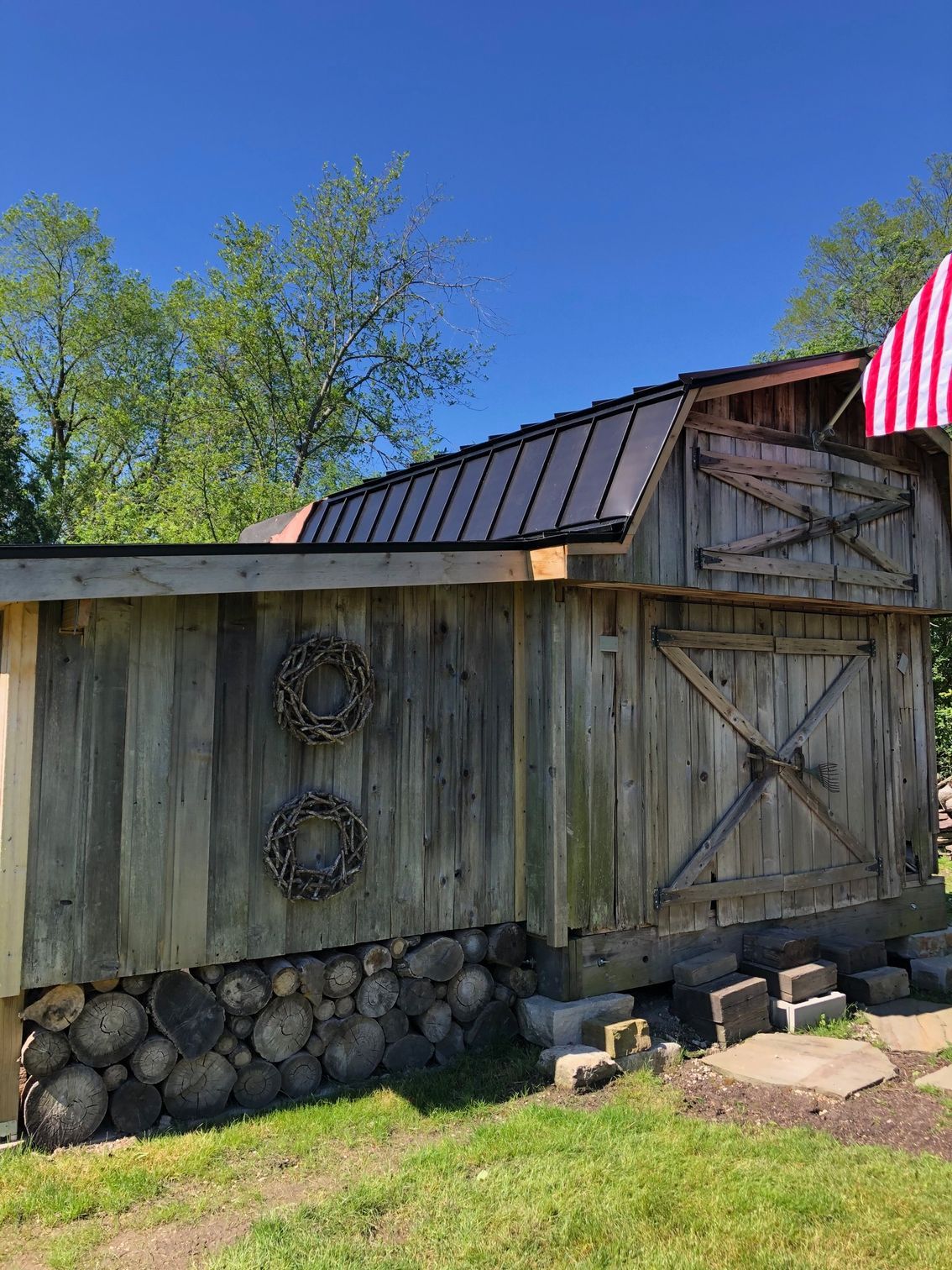 A wooden barn with a flag on top of it.