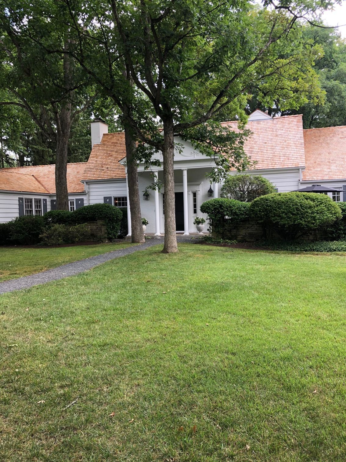 A large white house with a large lawn in front of it.