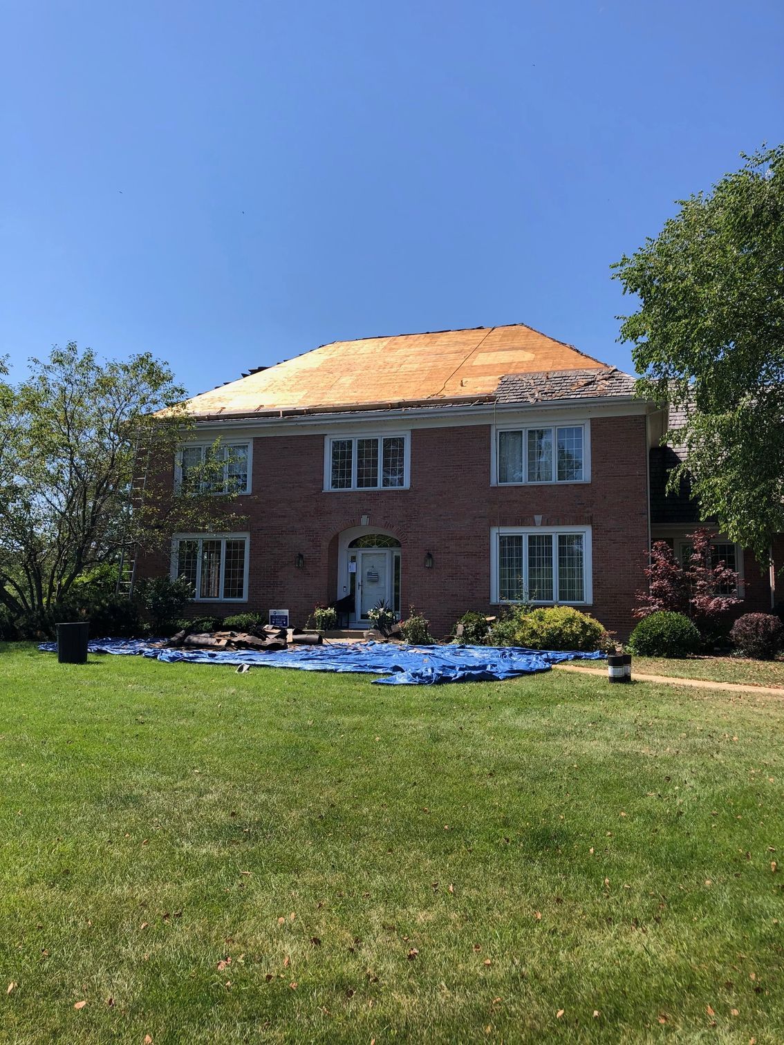 A large brick house with a wooden roof is being remodeled.