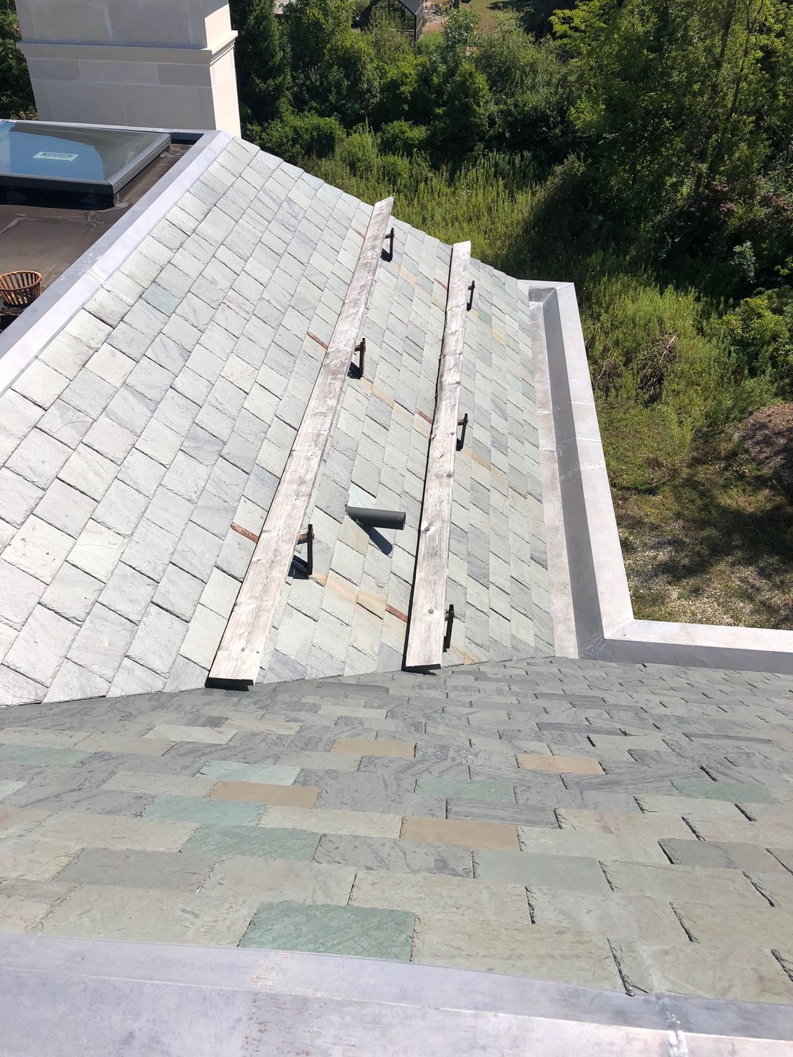 An aerial view of a roof with trees in the background.