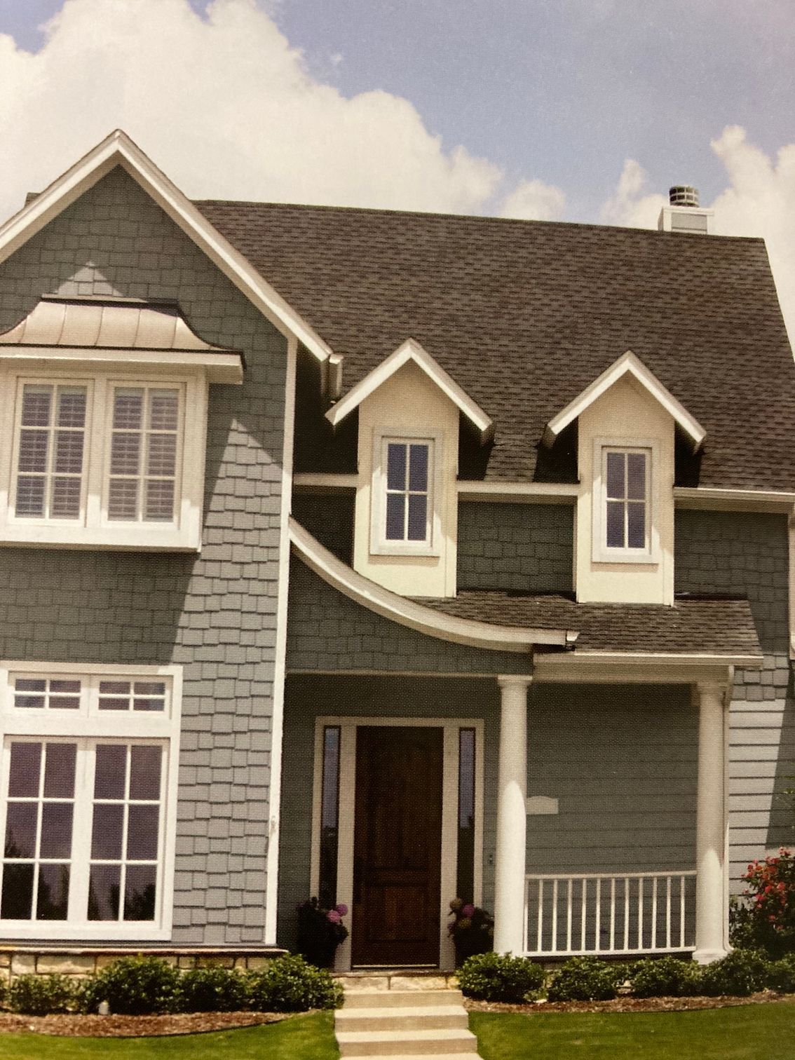 A blue house with white trim and a gray roof