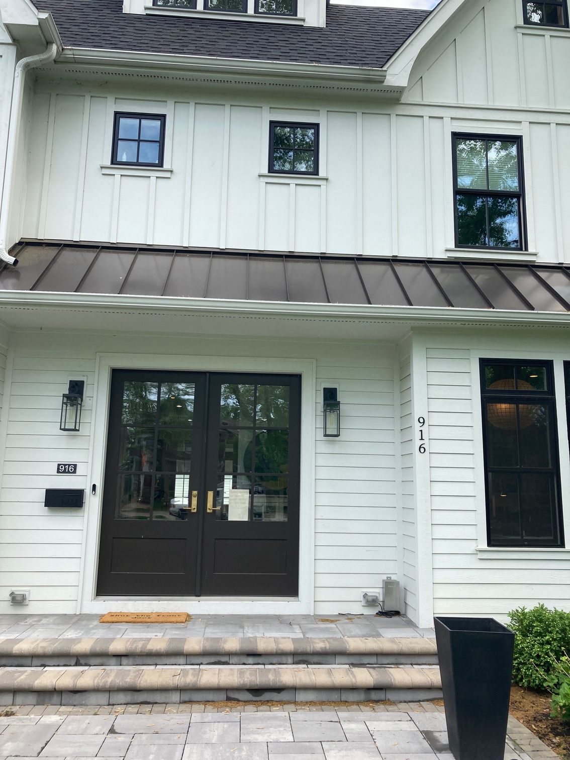The front of a white house with black doors and windows