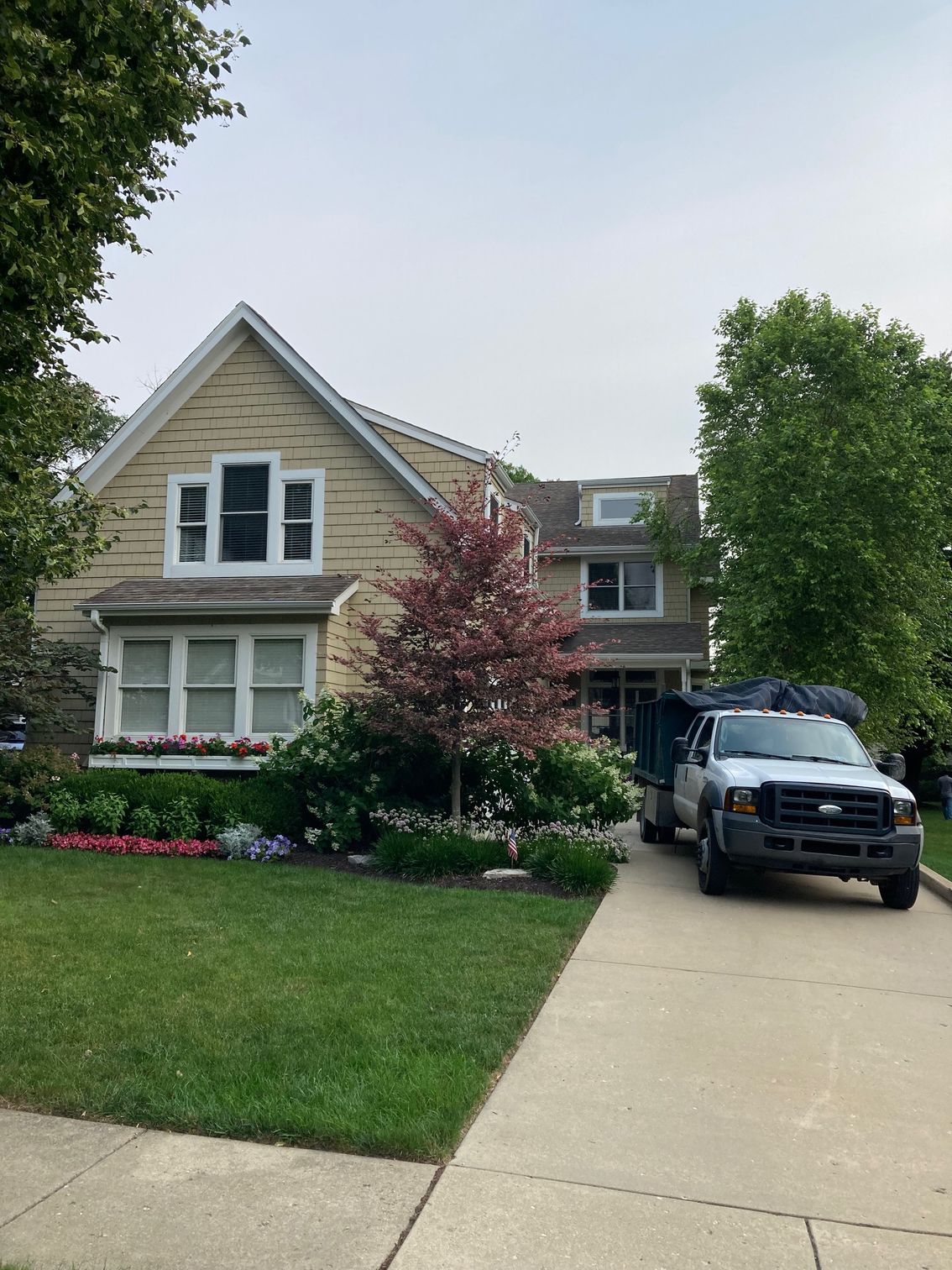 A white truck is parked in front of a house.