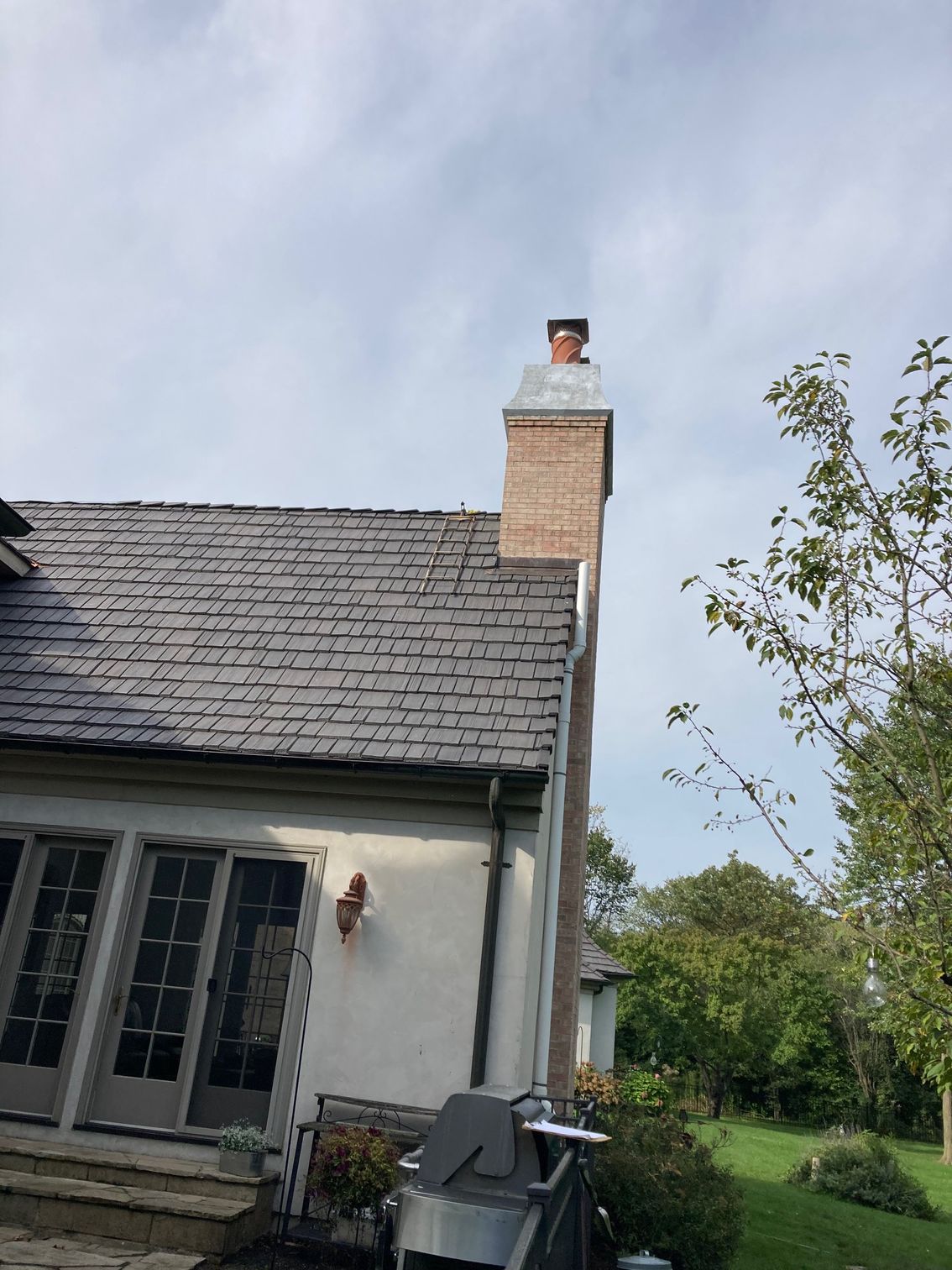 A white house with a brick chimney on the roof.