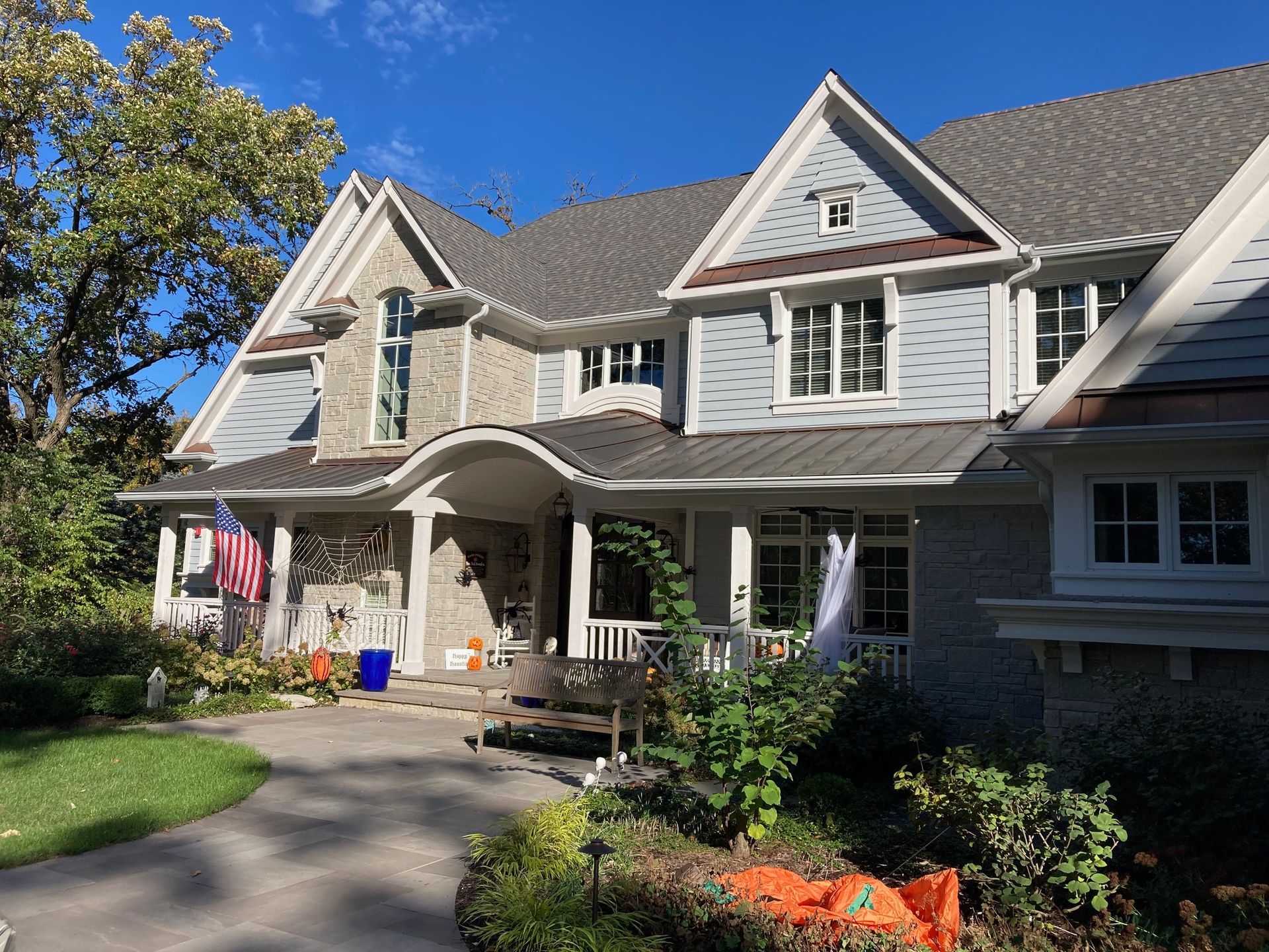 A large house with a large porch and a gray roof