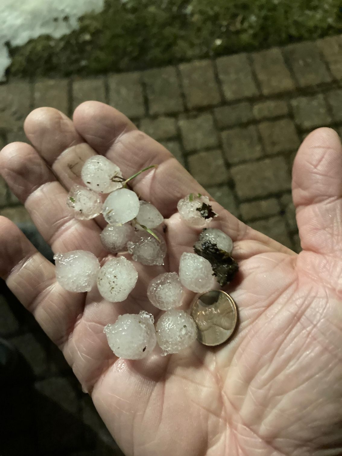 A person is holding a pile of hail in their hand.