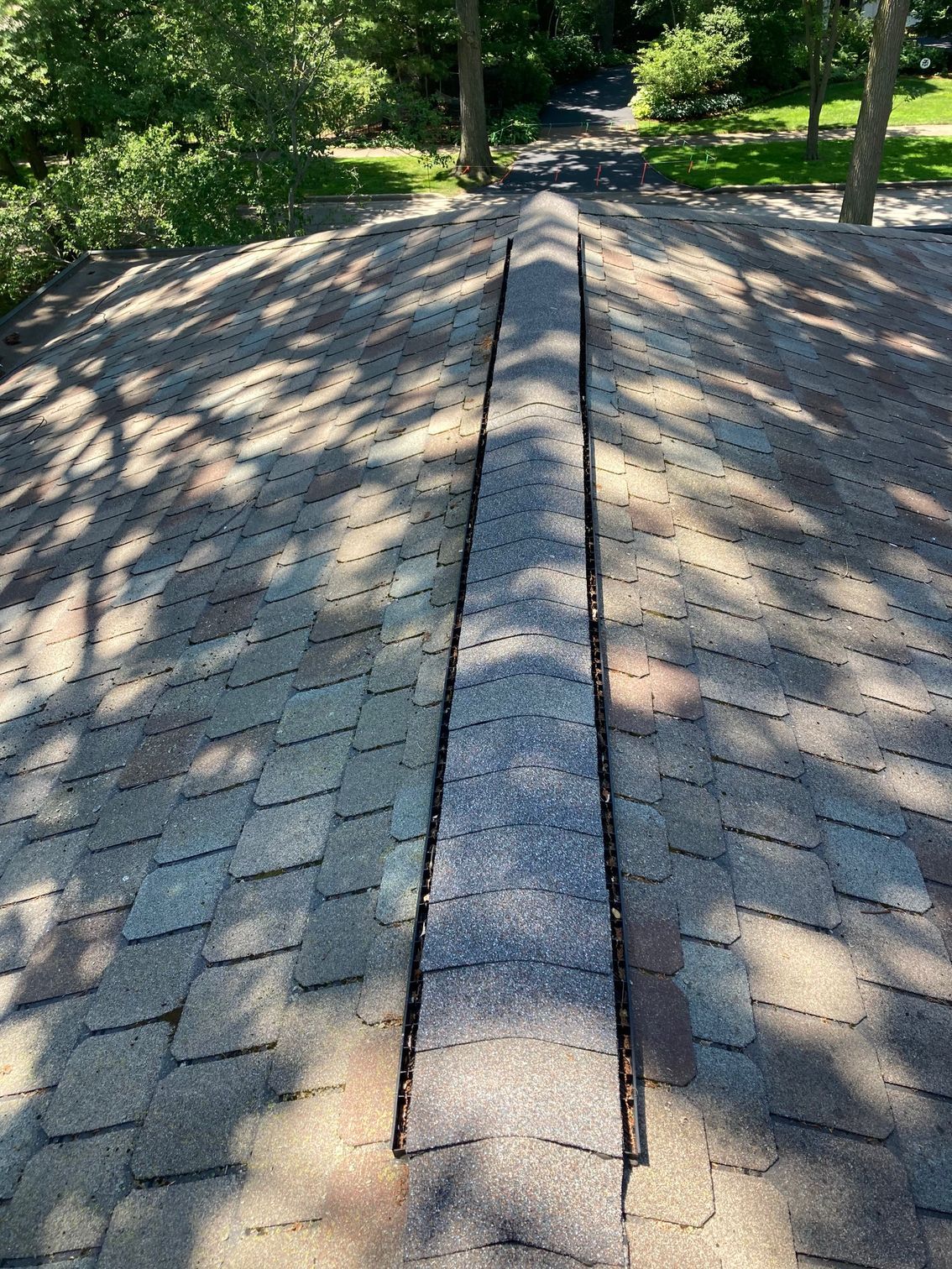 A roof with a hole in it and trees in the background.
