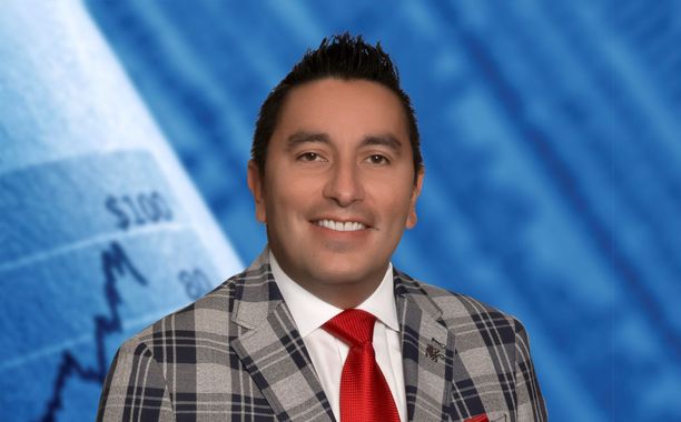 A man in a suit and tie is smiling in front of a graph.
