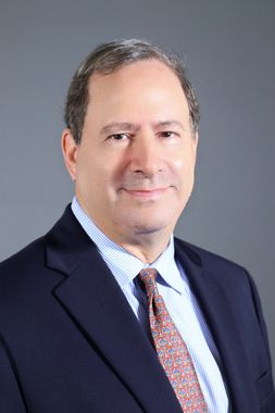 A man in a suit and tie is smiling for the camera.