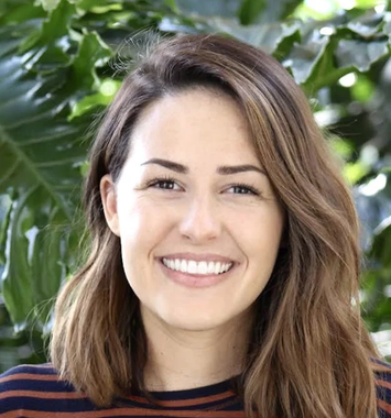 A woman in a striped shirt is smiling for the camera.