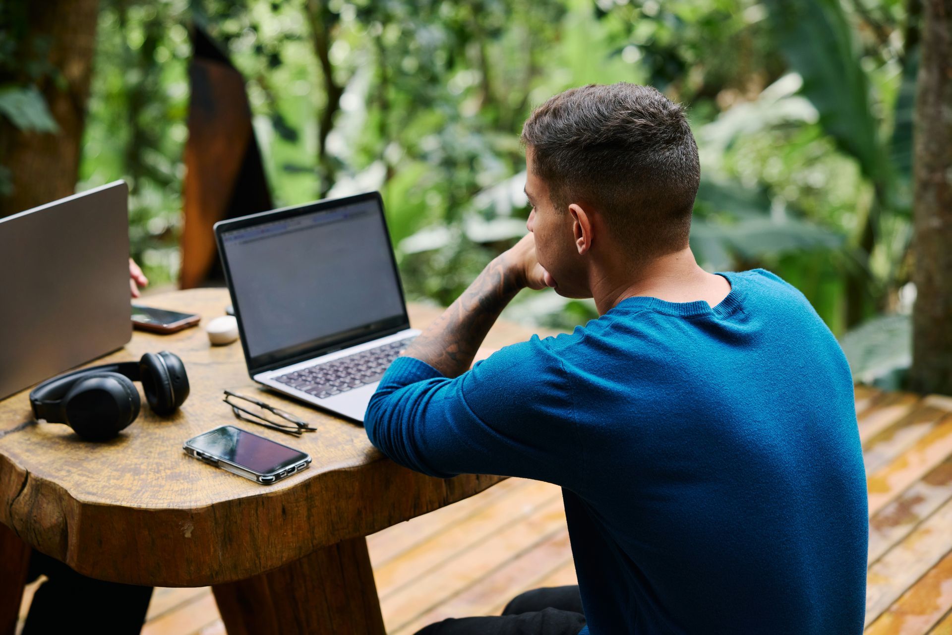 A man and a woman are shaking hands in front of a laptop.