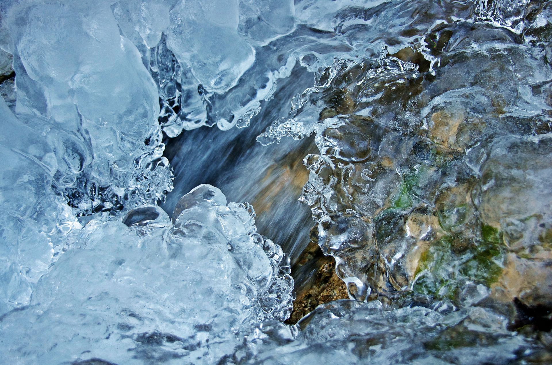 A close up of a stream of water surrounded by ice