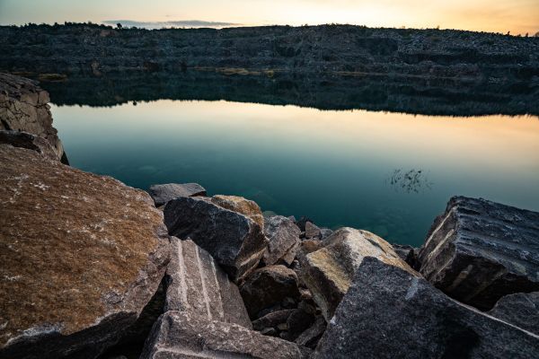 There are rocks in the foreground and a lake in the background.