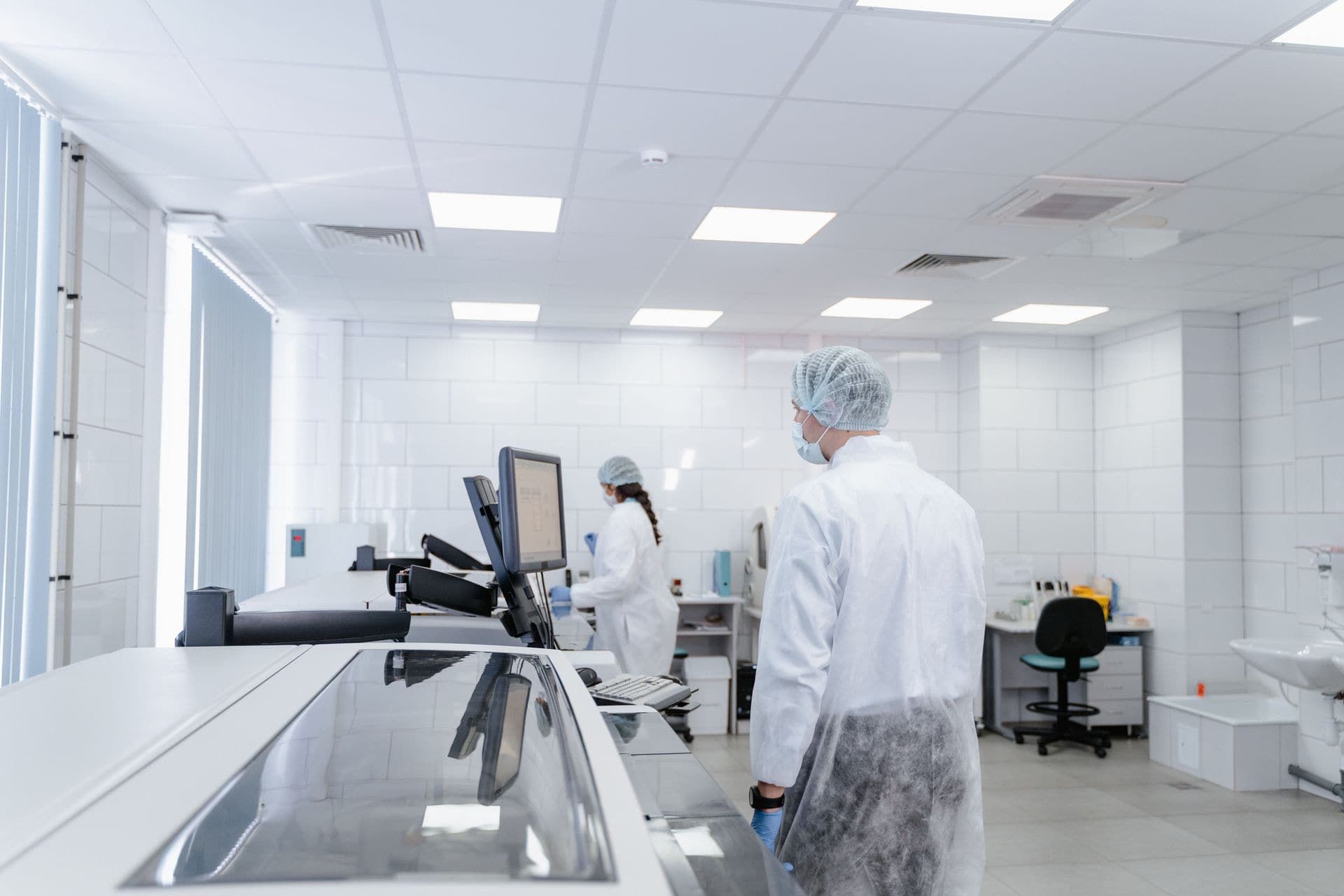Researchers wearing white lab coats in a clean lab.