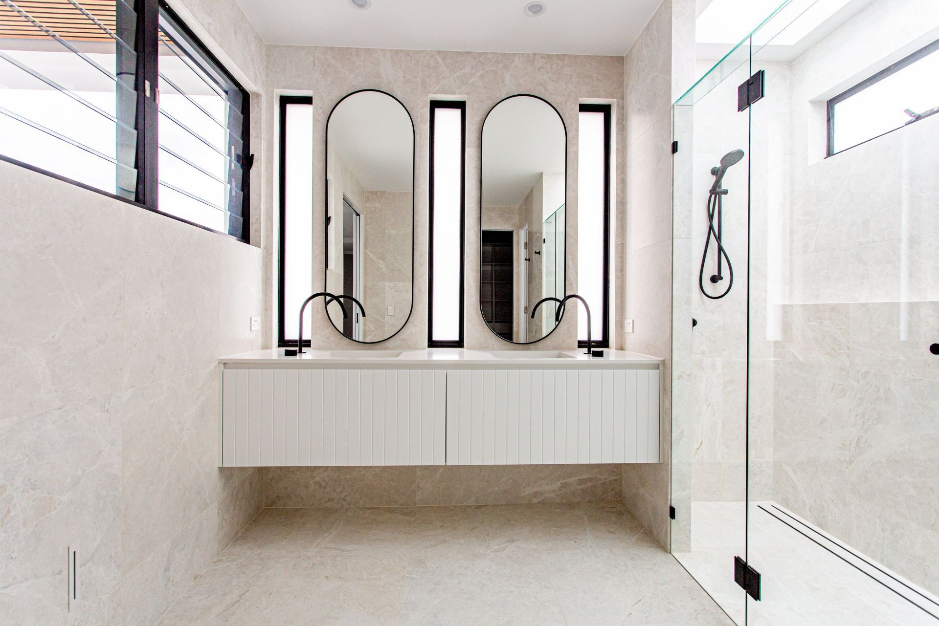 Double vanity with stone-look tiles and vertical mirrors – Camp Hill bathroom