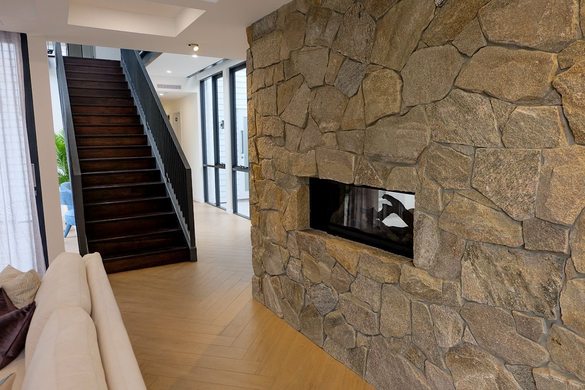 Stone feature fireplace wall with herringbone tiled floor – Pelham project