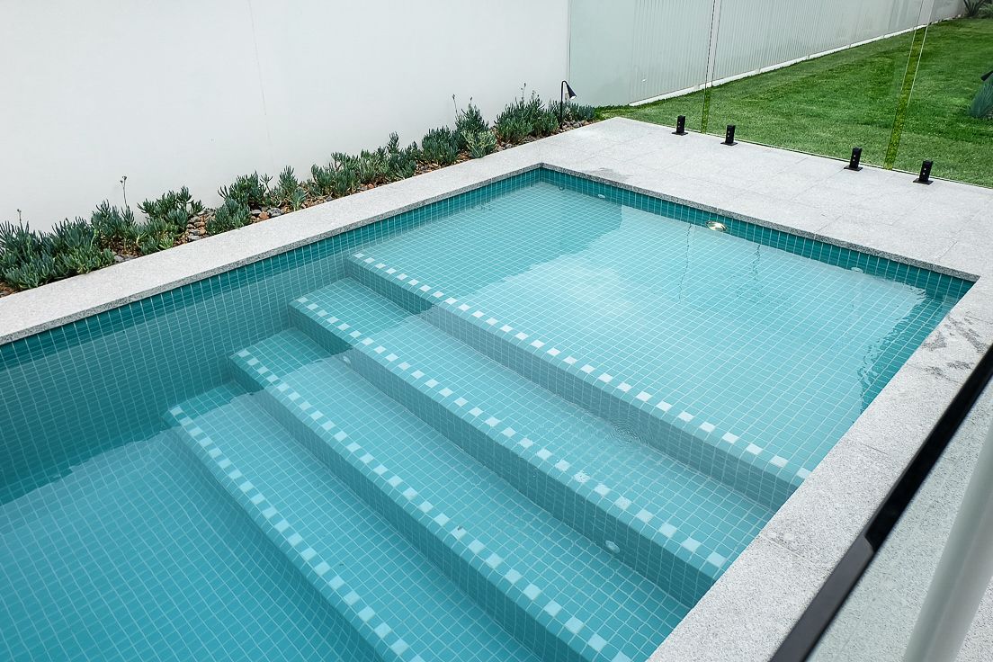 Mosaic pool steps with clean grout lines and tiled surround – Pelham project