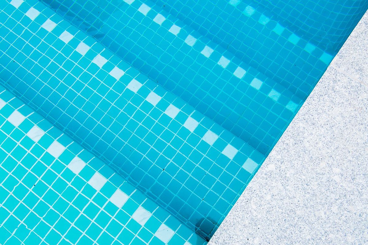 Pool steps with blue mosaic tiles and granite coping – Ascot residential tiling project