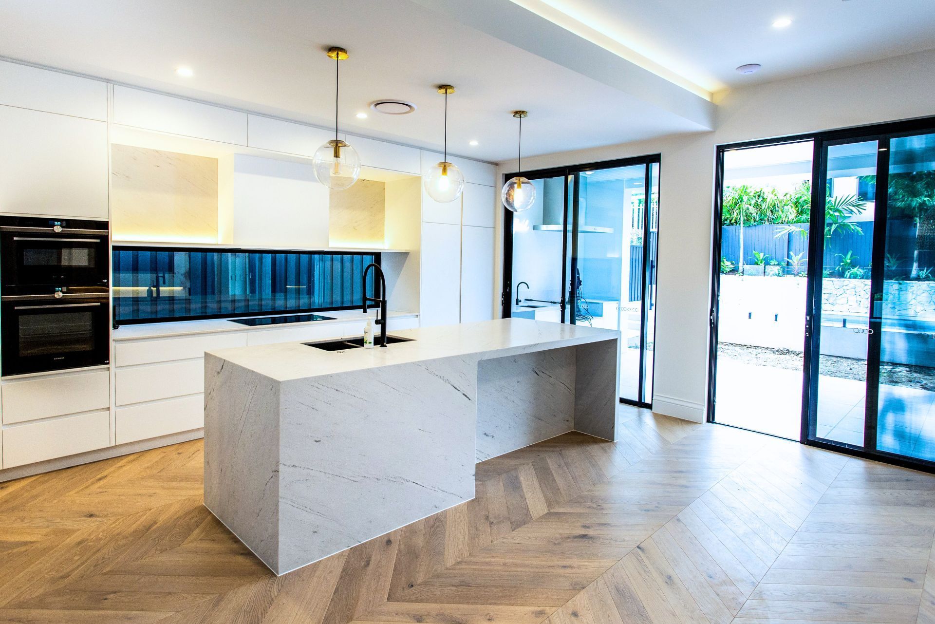 Kitchen with stone island, splashback and herringbone tile flooring – Camp Hill