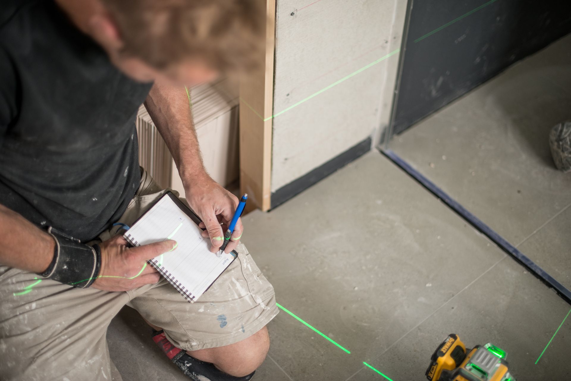 tiler taking measurements and notes
