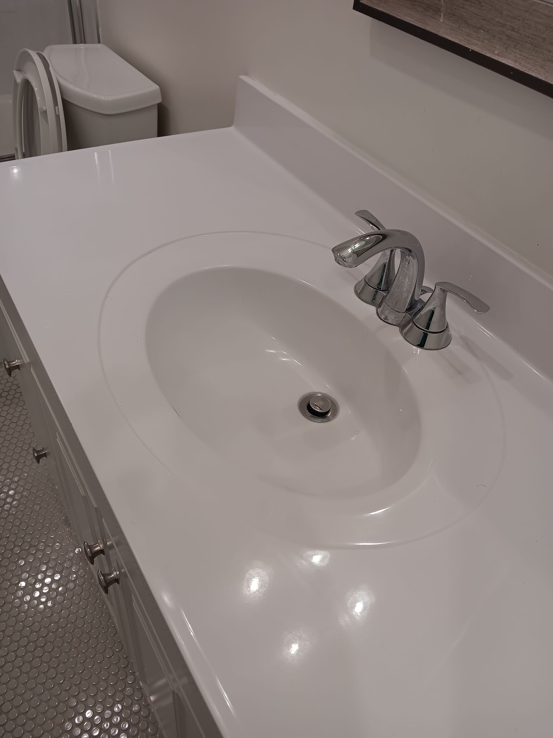 A bathroom sink with a toilet in the background.