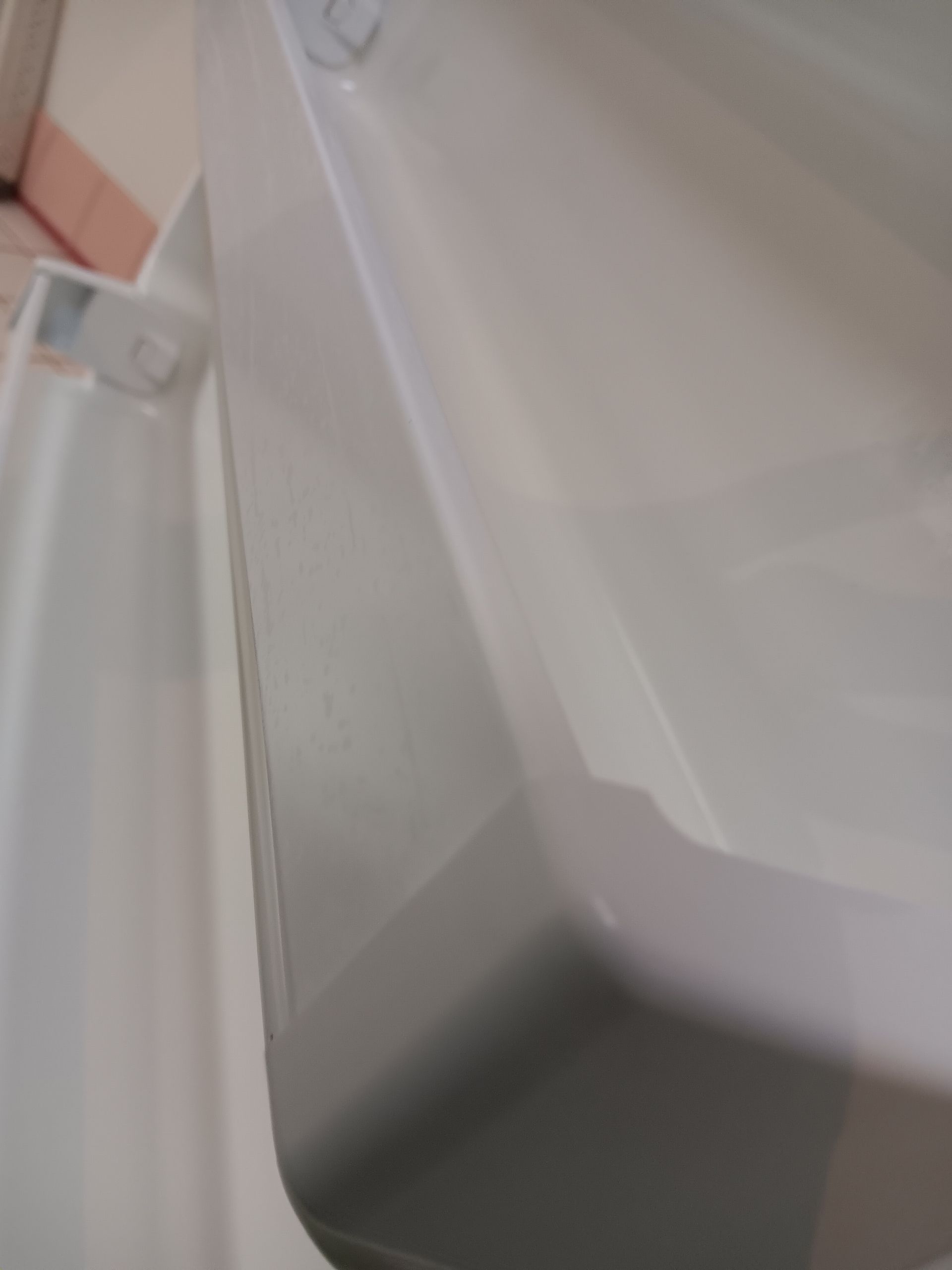 A close up of a white toilet with a shadow on the floor