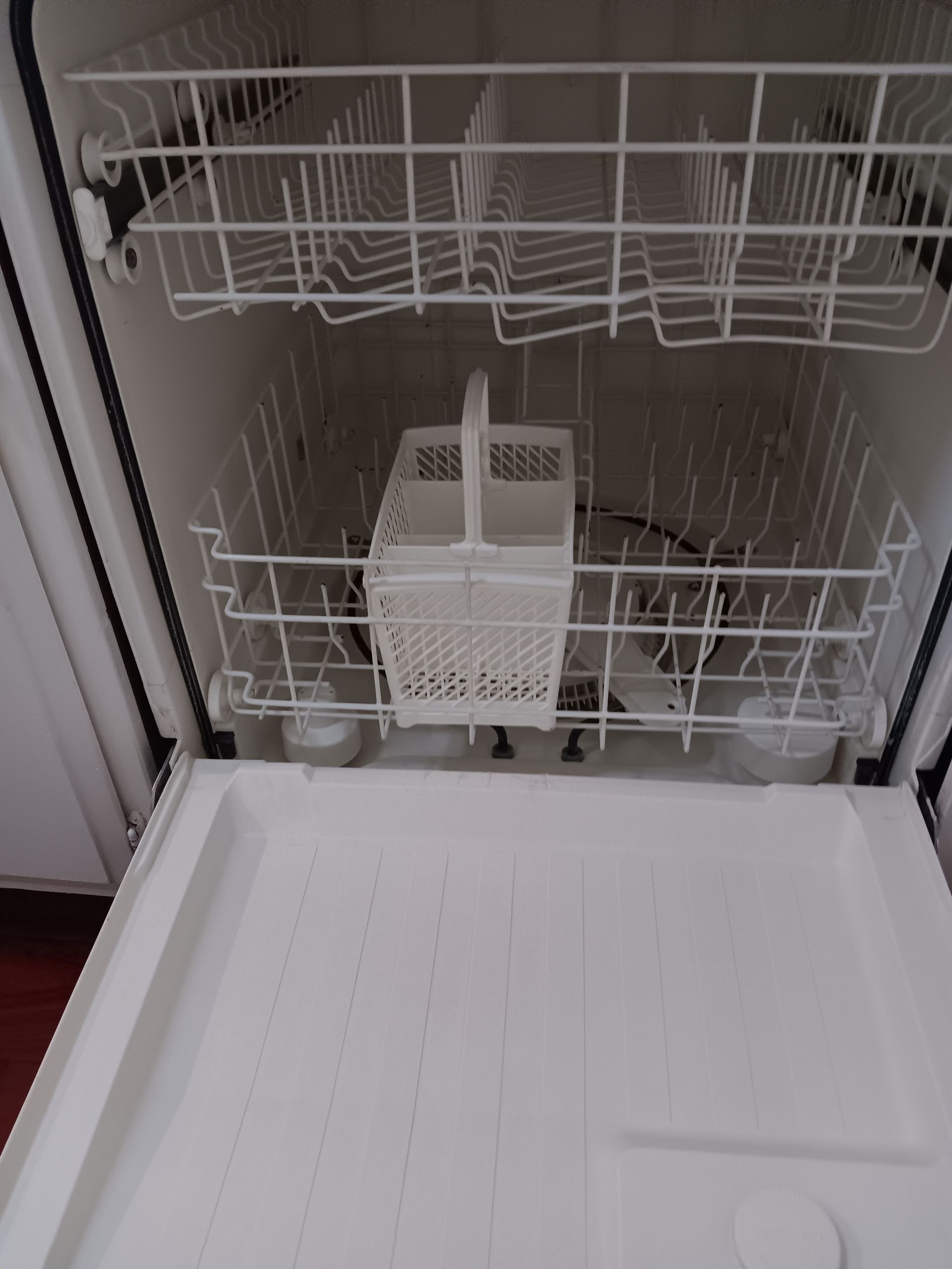 A dishwasher with the door open and a basket in it.