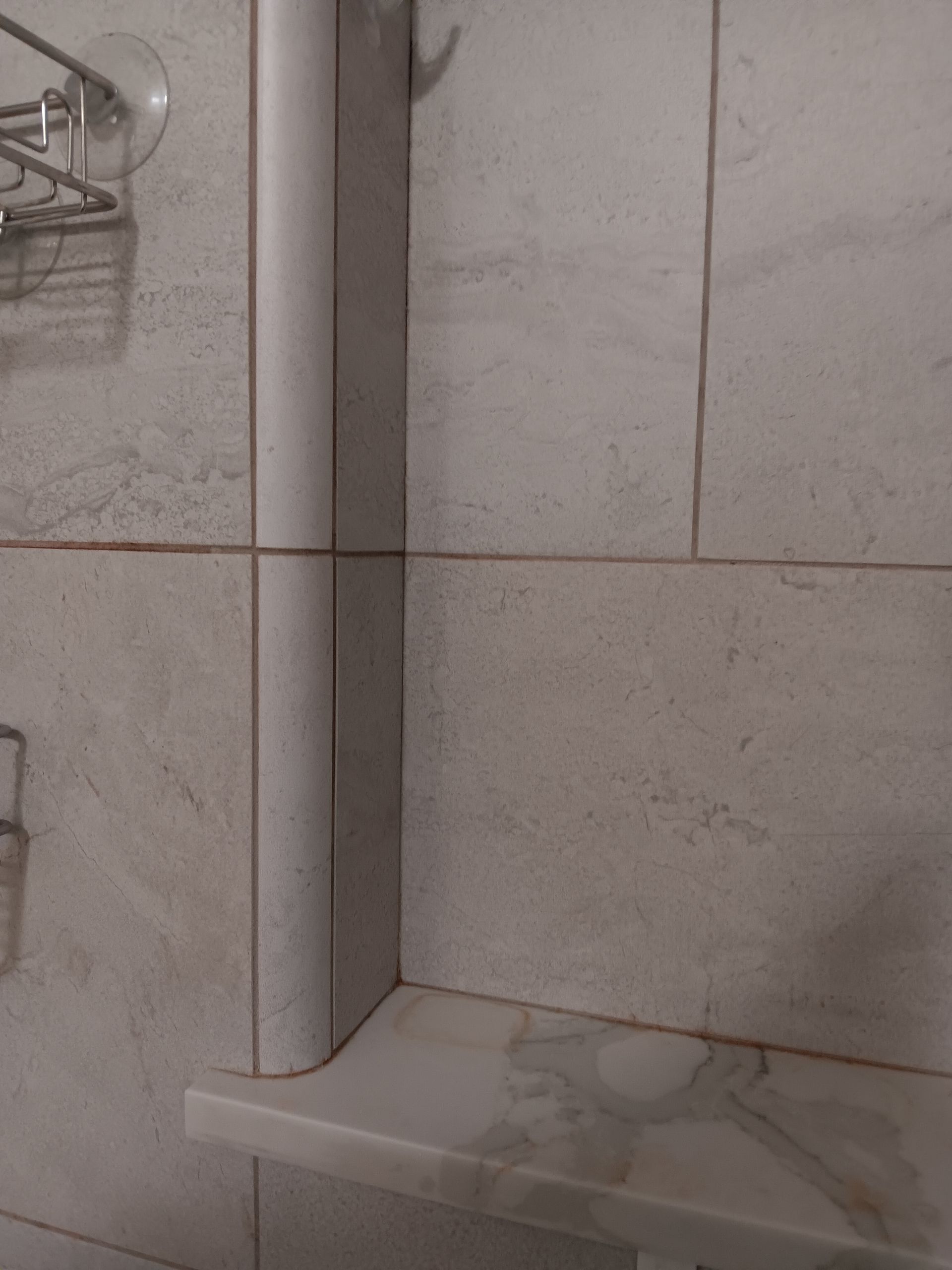 A toilet paper roll is sitting on a shelf in a bathroom.