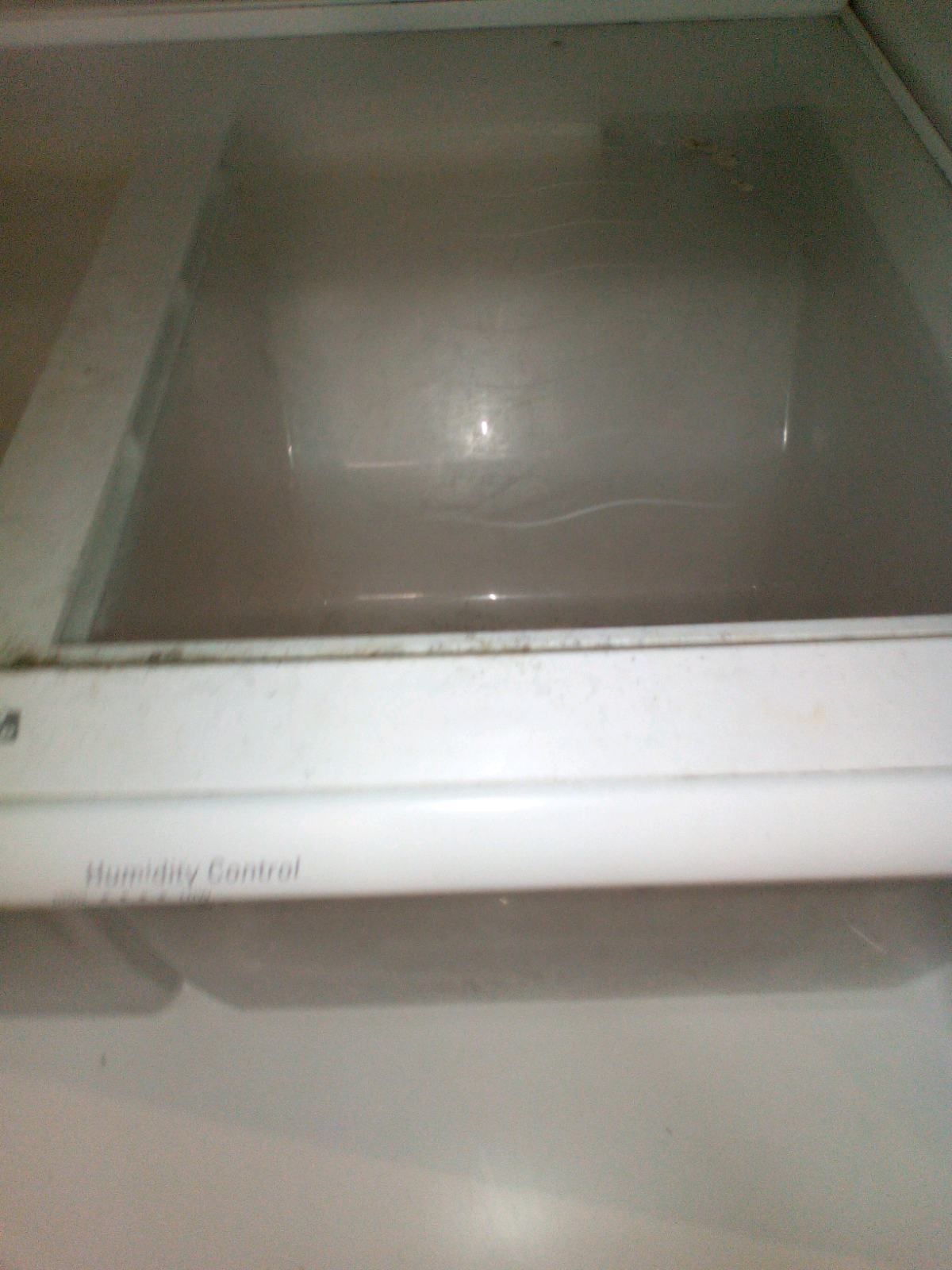 An empty refrigerator drawer with a humidity control label on it