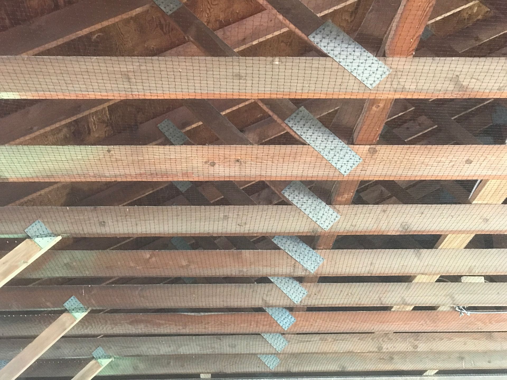 A close up of the ceiling of a building with wooden beams.