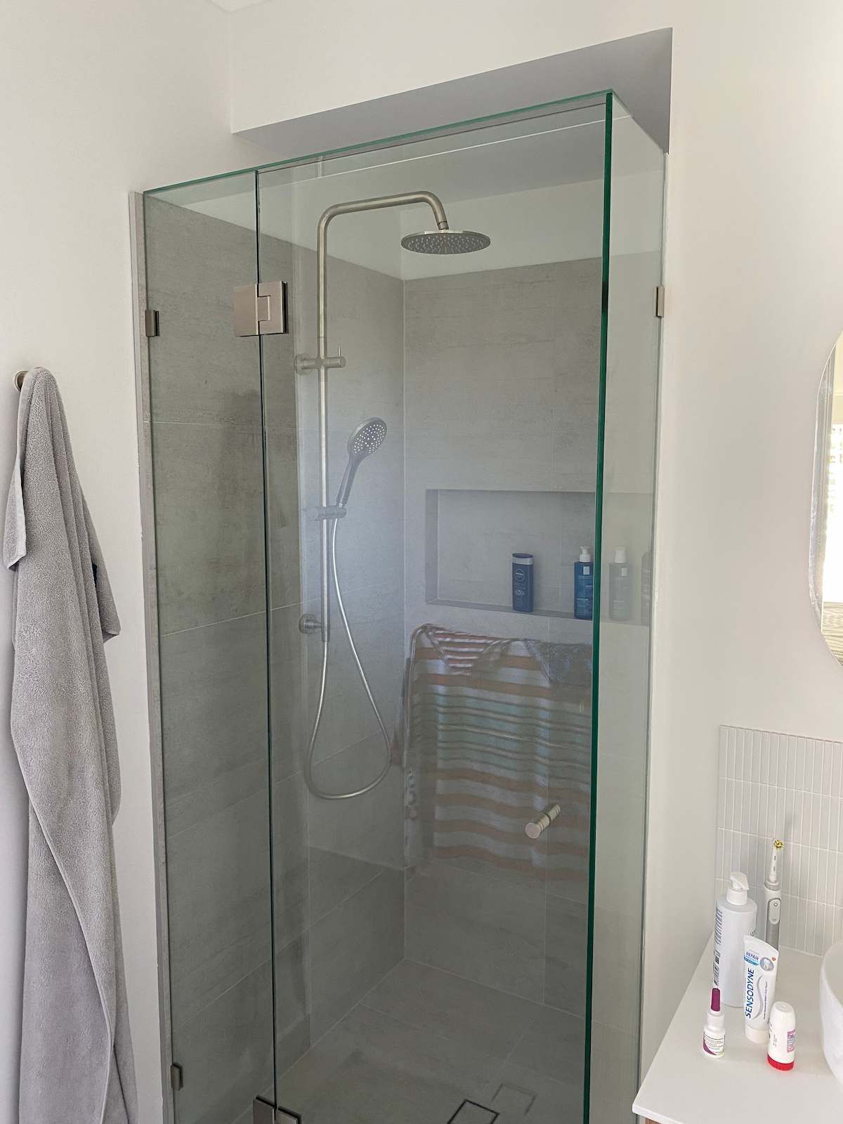A Bathroom With a Glass Shower Door and a Shower Head — Nick Hall Builder in Maroochydore, QLD