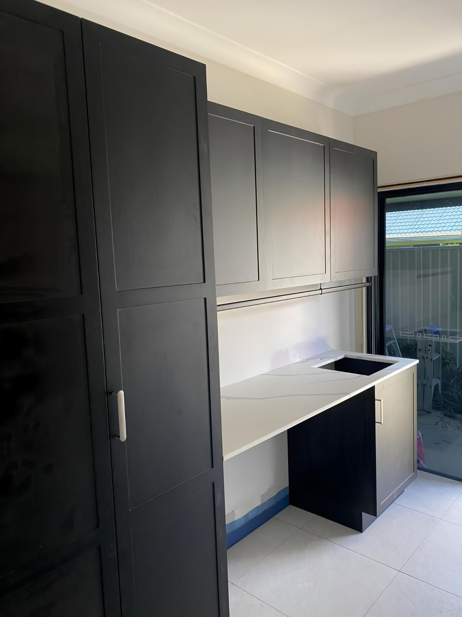 A kiTchen with Black Cabinets and A White Counter Top — Nick Hall Builder in Nambour, QLD